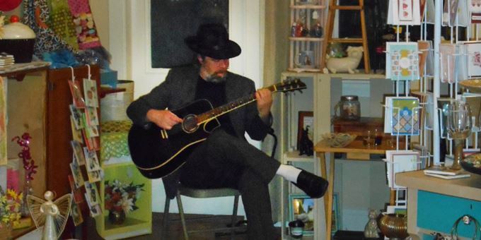 A musician plays in a downtown boutique during Spring Gallery Night.