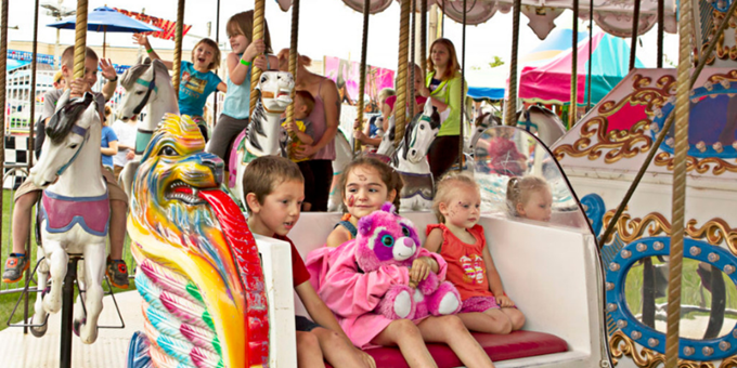 Children on merry-go-round at carnival.