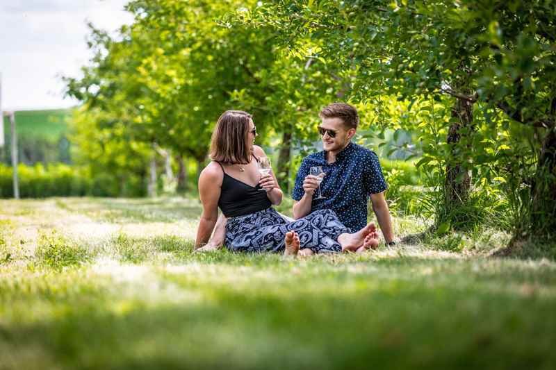 Couple enjoying wine in apple orchard at Maiden Rock Apples, Winery & Cidery in Stockholm
