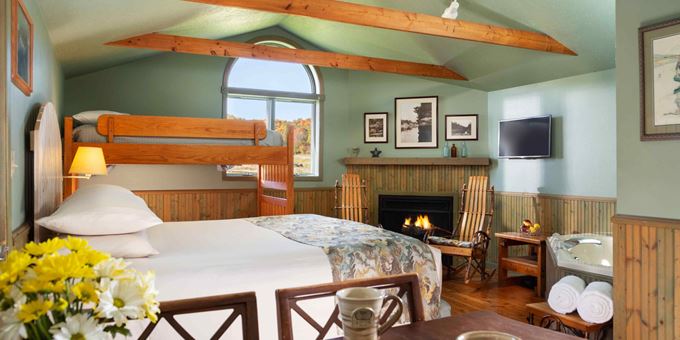 Dining table &amp; chairs, king-size bed, bunk beds and fireplace inside The Cottage at Justin Trails Resort