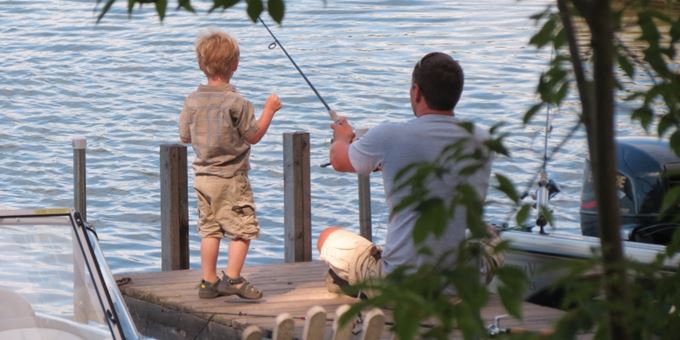 Dad and son enjoying morning fishing on the pier