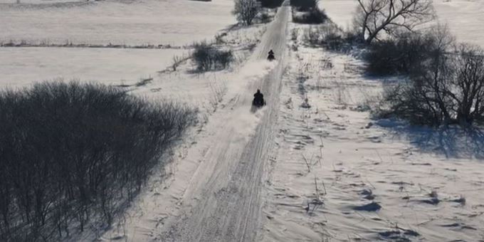 Snowmobilers on an open trail