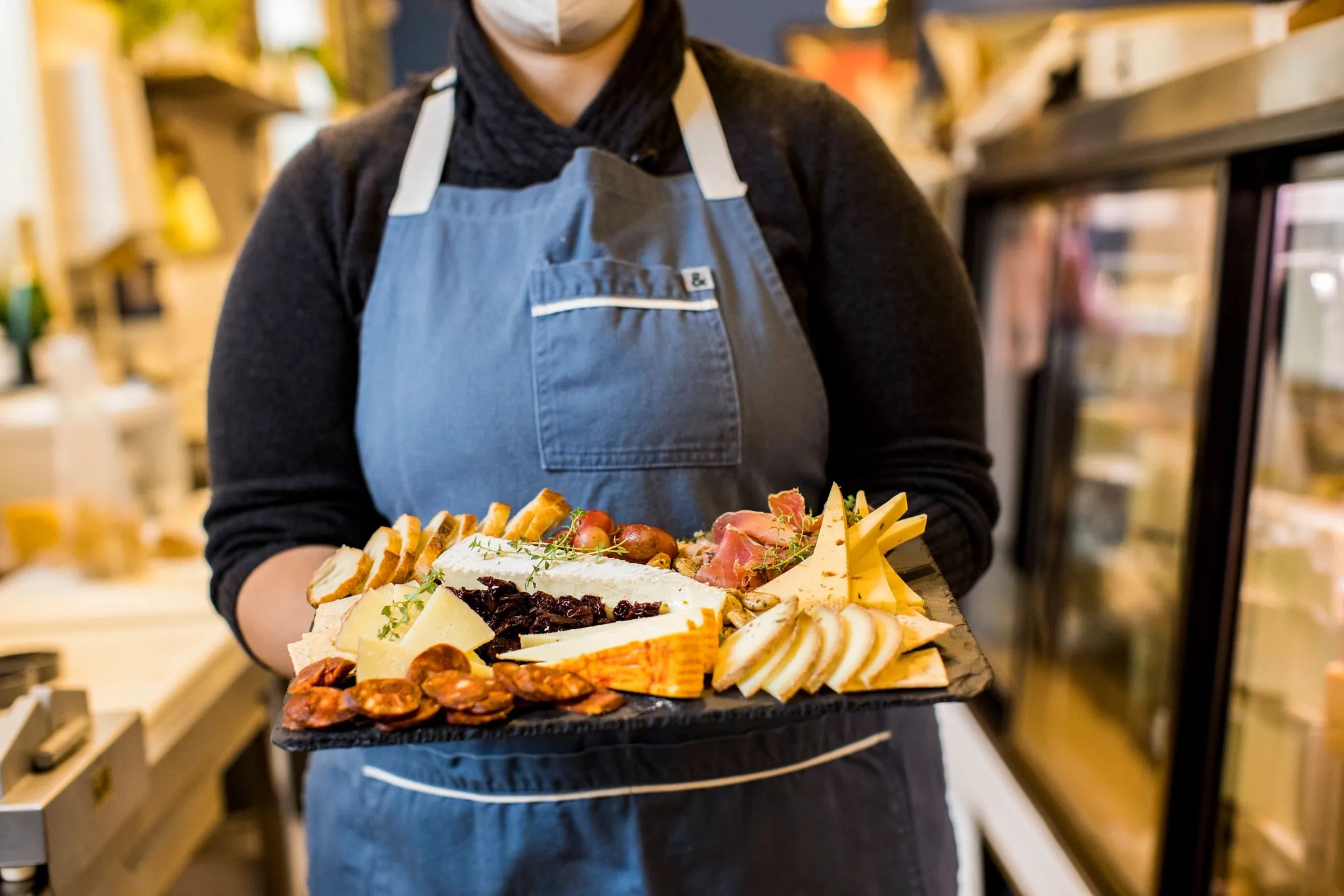 person holding cheese charcuterie board person holding cheese charcuterie board
