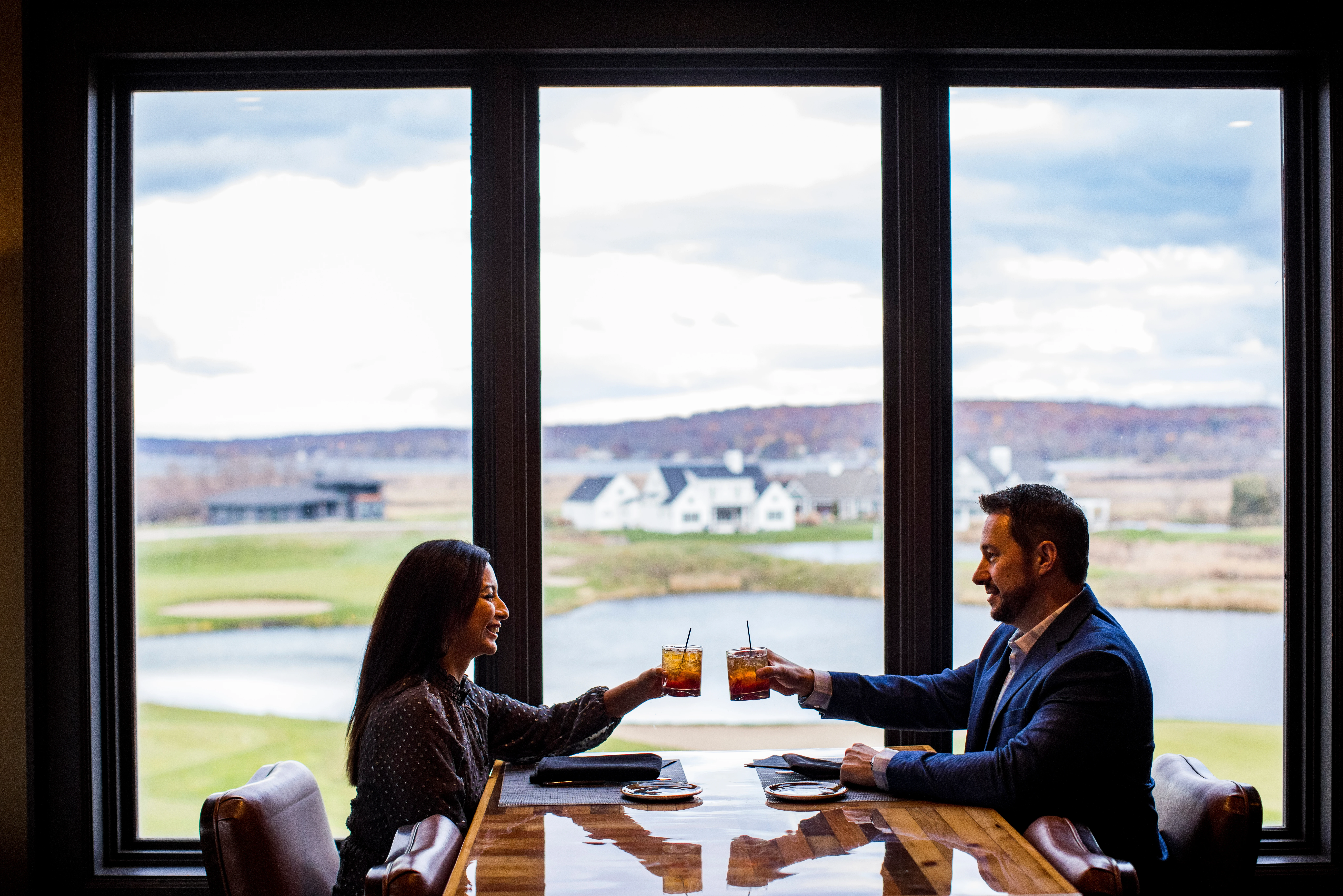 Couple cheers with drinks at hunt club steakhouse lake geneva