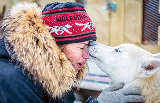 12326c24-d59a-4881-9ef2-39dba707f346-070-apostle-islands-sled-dog-race,-lady-with-dog-face-to-face.