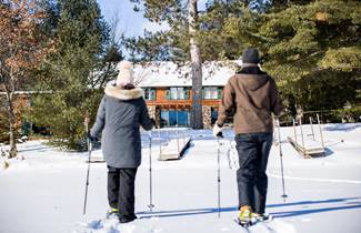 4ba81928-78bb-4b92-9e30-83e2eb044e22-043-friends-snowshoe-across-a-frozen-lake-near-whispering-pine-lodge-in-st