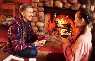 87d34b3d-5630-42b5-b0c5-392a59a07158-103-mom-and-daughter-warm-up-by-the-fireplace-at-the-coons-franklin-lodge-in-woodruff