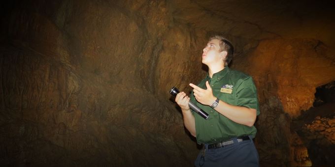 Tour Guide shows off cave in darkness