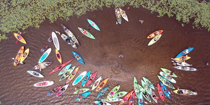 Overview image of a group of canoes on the river.