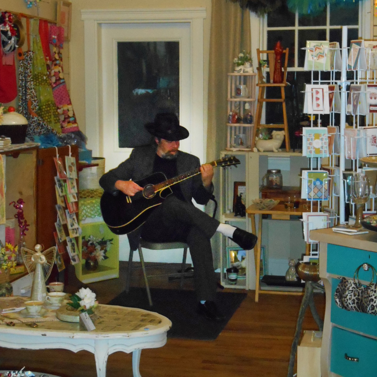 A musician plays in a downtown boutique during Spring Gallery Night.