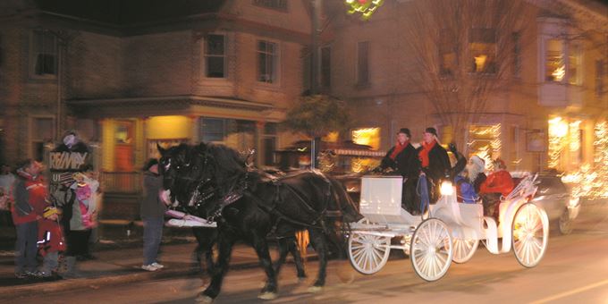 Santa and Mrs. Claus arrive in a horse-drawn carriage.