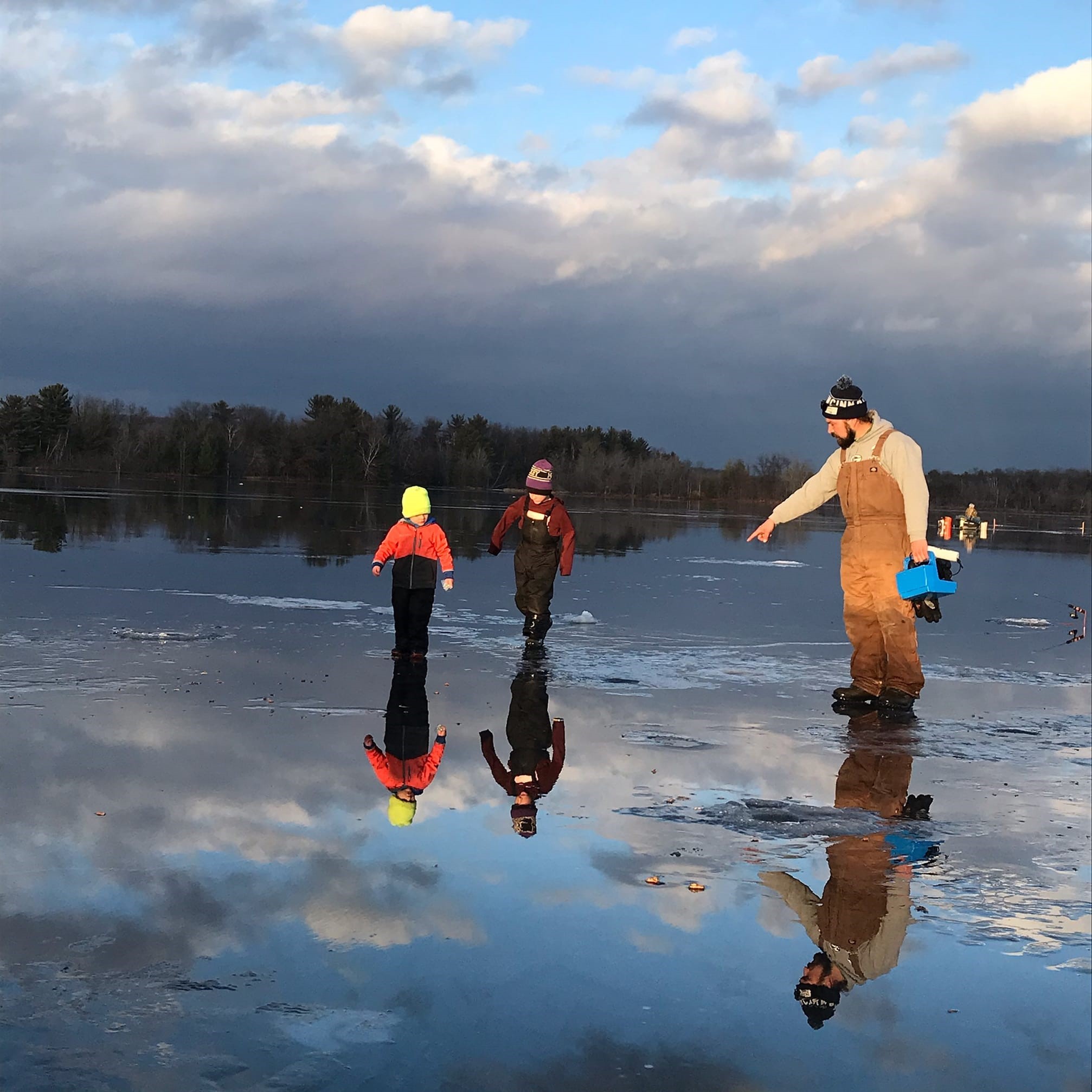 Family on ice preparing to fish.