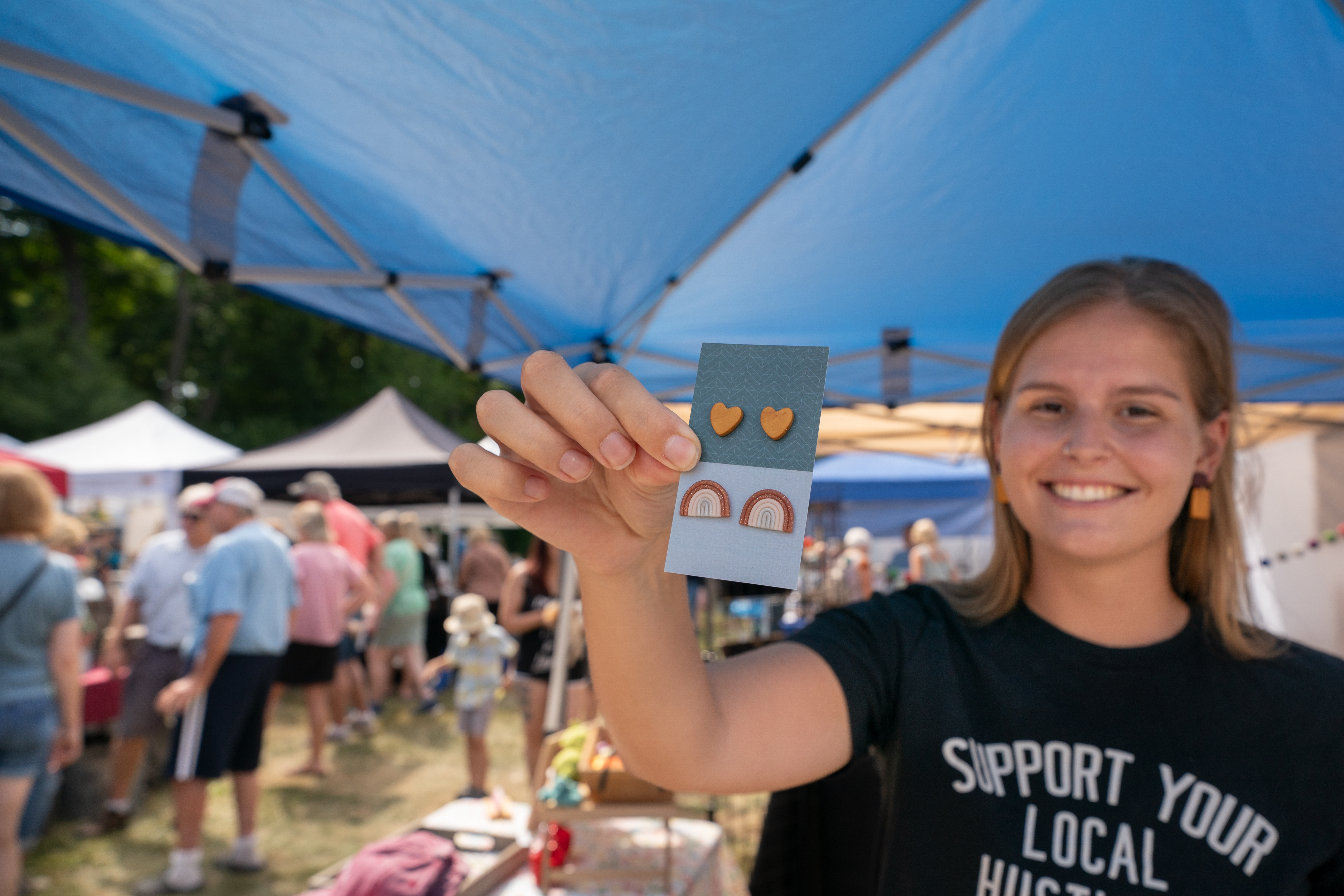 A maker showcases jewelry at Faire on the Green.