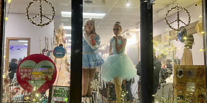 Dancers pose in shop windows