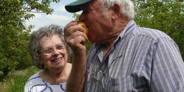 Gharleen &amp; Rex Moseley. Rex biting into a Honeycrisp apple.
