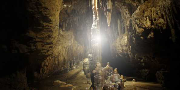 Flashlight shining on cave formations