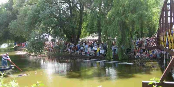 Event Goers Line the River Banks During the Duck Race