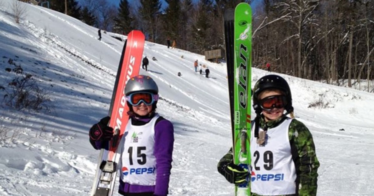 Girl with skis and number to compete on ski jump at Tri-Norse Ski Club.