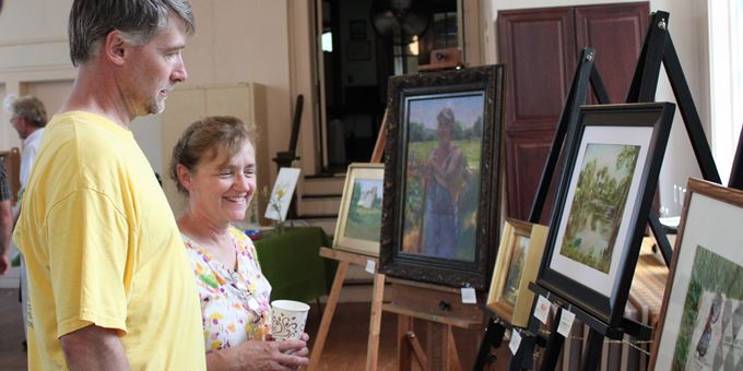 Patrons admire the pretty results of the Theodore Robinson Plein Air Painting Contest, hosted in Evansville.