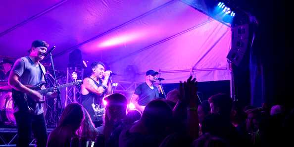 Crowds rock out during live music performances by IV Play at River Falls Days 2019.
