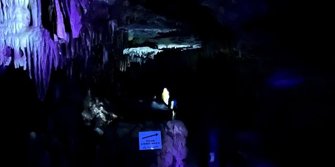 Cave formations that are typically brown or tan in color are now purple and teal.