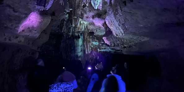 Guests are in awe of the glowing formations on a Blacklight Tour in Cave of the Mounds