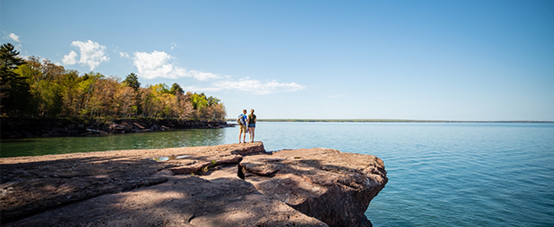 Couple standing on a cliff overlooking Lake Superior at Big Bay State Park