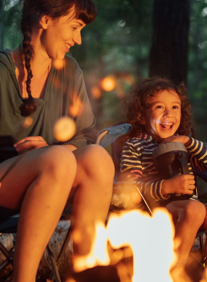 mom and son sitting around a bonfire