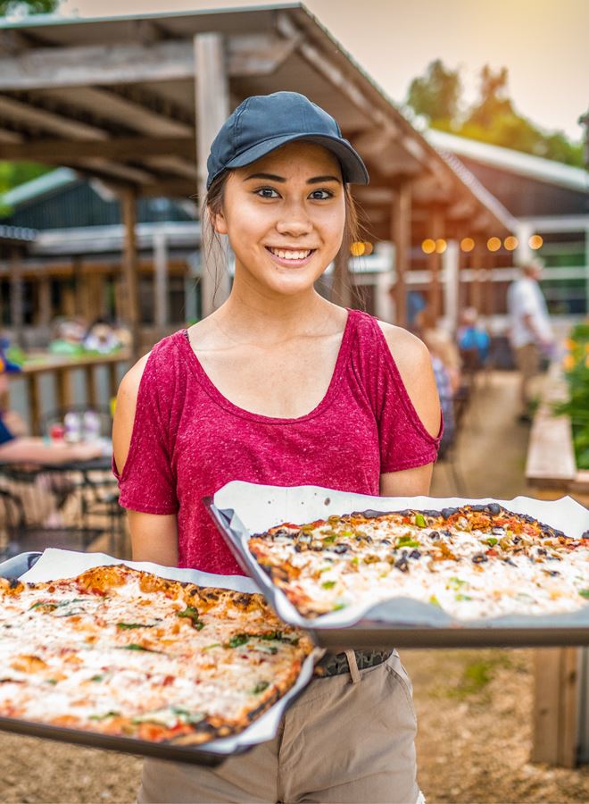 server with pizza at stone barn pizza farm