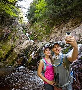 Couple Taking Selfie Near Waterfall