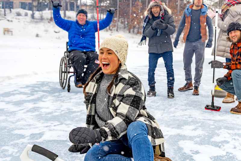 group of friends cheering on a woman curling at sand valley resort
