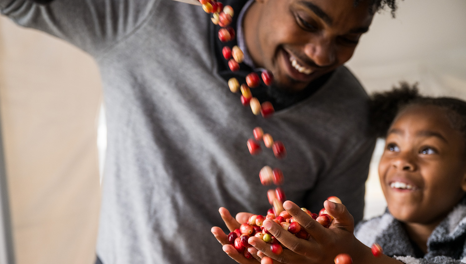 little girl smiling and holding a handful of cranberries