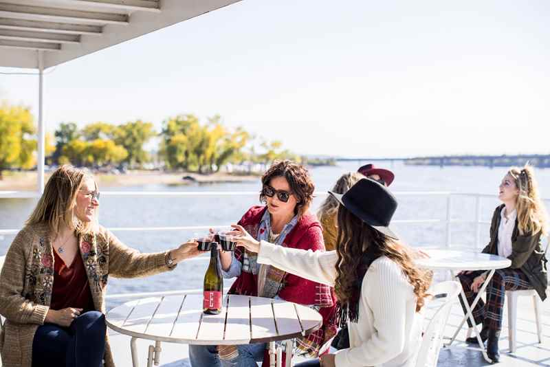 women drink wine on a boat