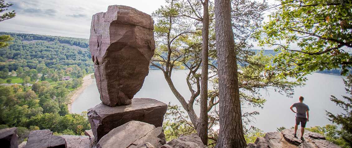 Man Standing Next to Balanced Rock at Devils Lake State Park