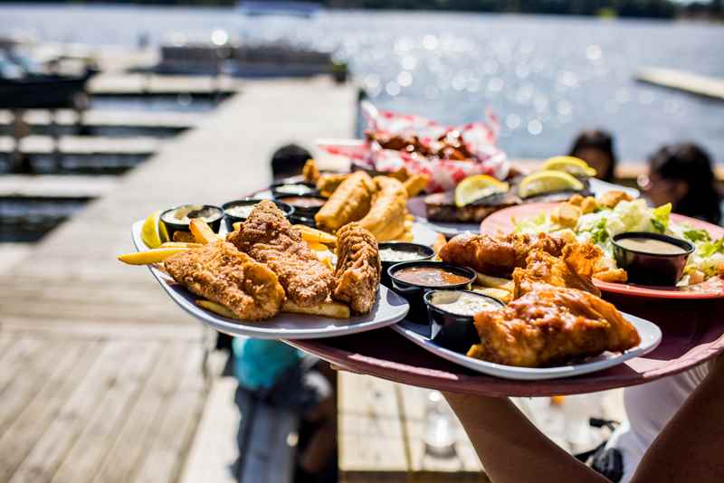 fish fry on a serving tray on a dock leading to a lake on a sunny day