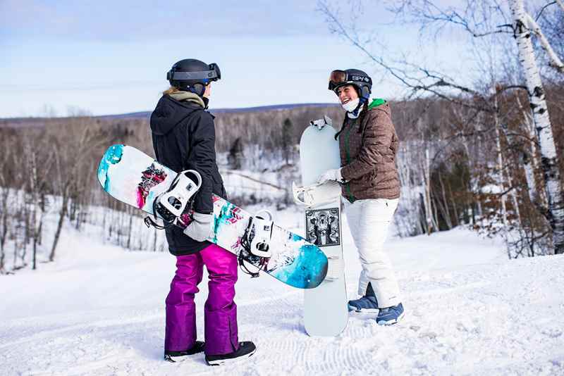 Snowboarders at the top of a ski hill