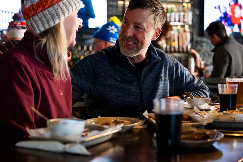 couple enjoying food while sitting at the bar