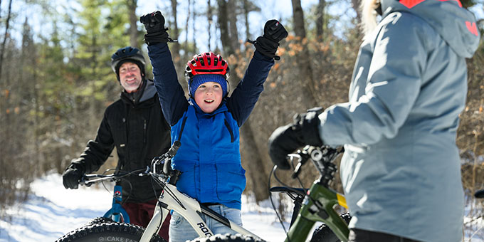 Son celebrating while fat tire biking with family