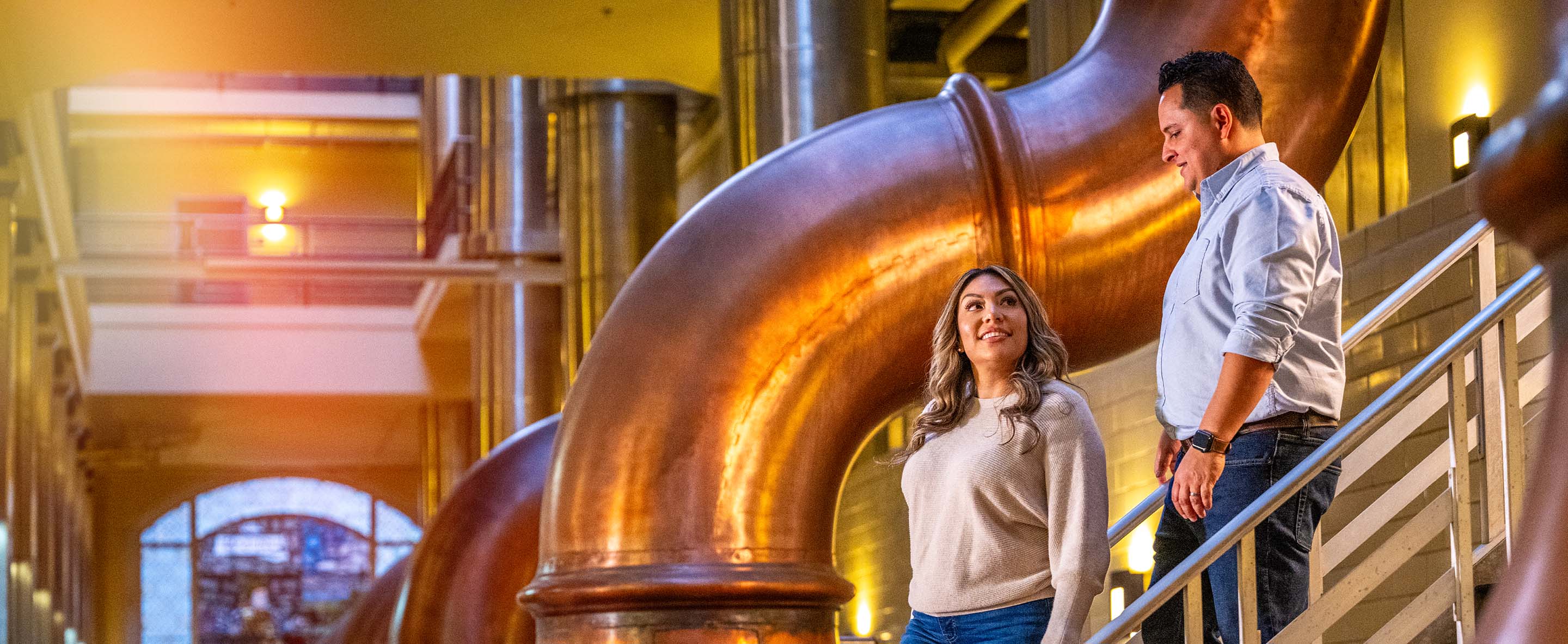 058 Man and Woman Walk Down Staircase at Brewhouse Inn and Suites
