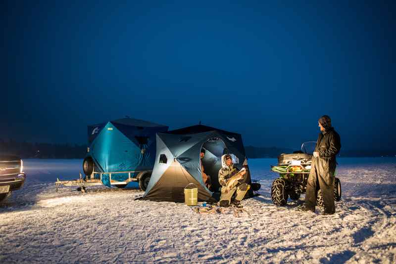 Group of people ice fishing with shanty's out on the lake