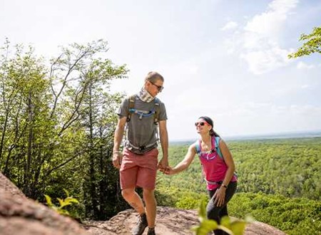 Couple hiking and holding hands loading=