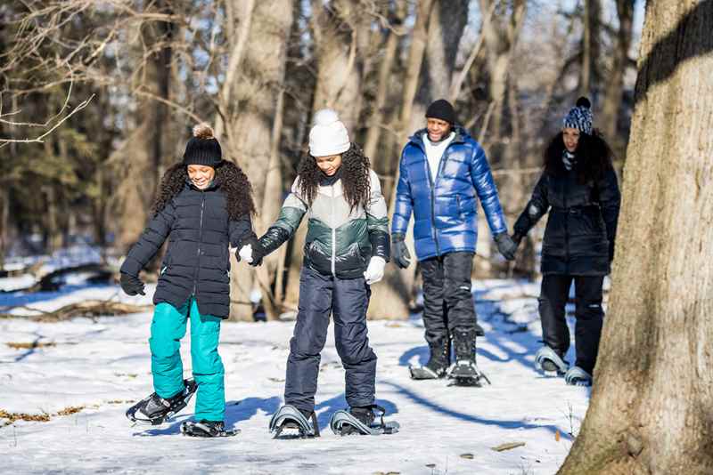 family on a snow shoe hike through the woods