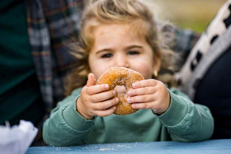 little girl showing off her donut