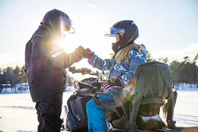Two snowmobilers fist pumping