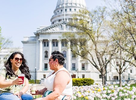 woment sitting in front of the captial building in madison loading=