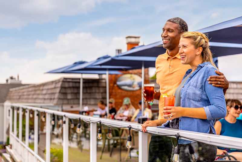 103 Couple Drink And Look Out On Lake Superior In Downtown Bayfield Couple having a drink on a patio standing at the railing looking out