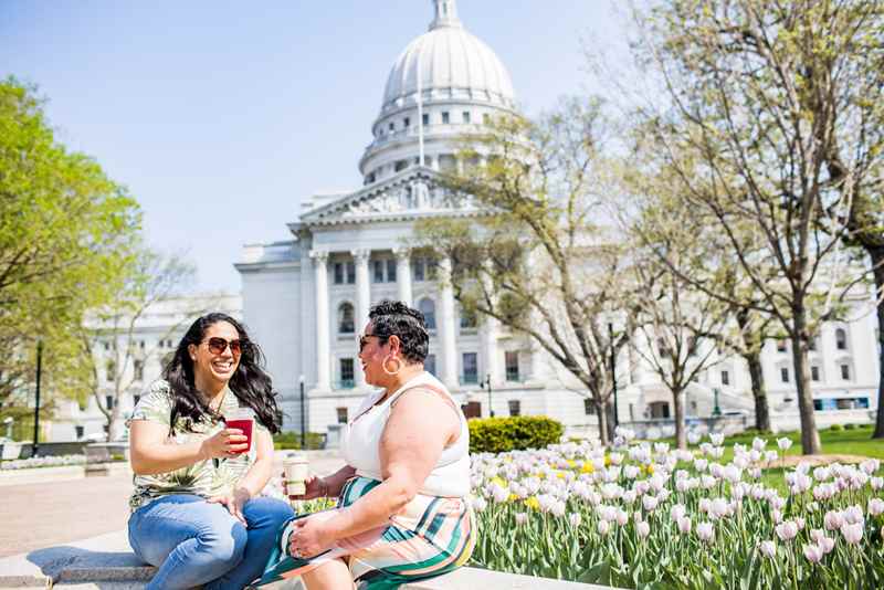 Friends enjoying cafe drinks in front of the Wisconsin Capitol Building