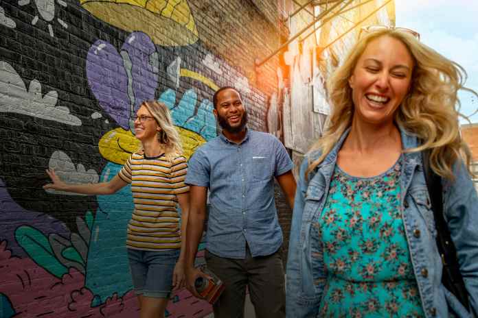 group of friends walking through black cat alley and enjoying the graffiti artwork