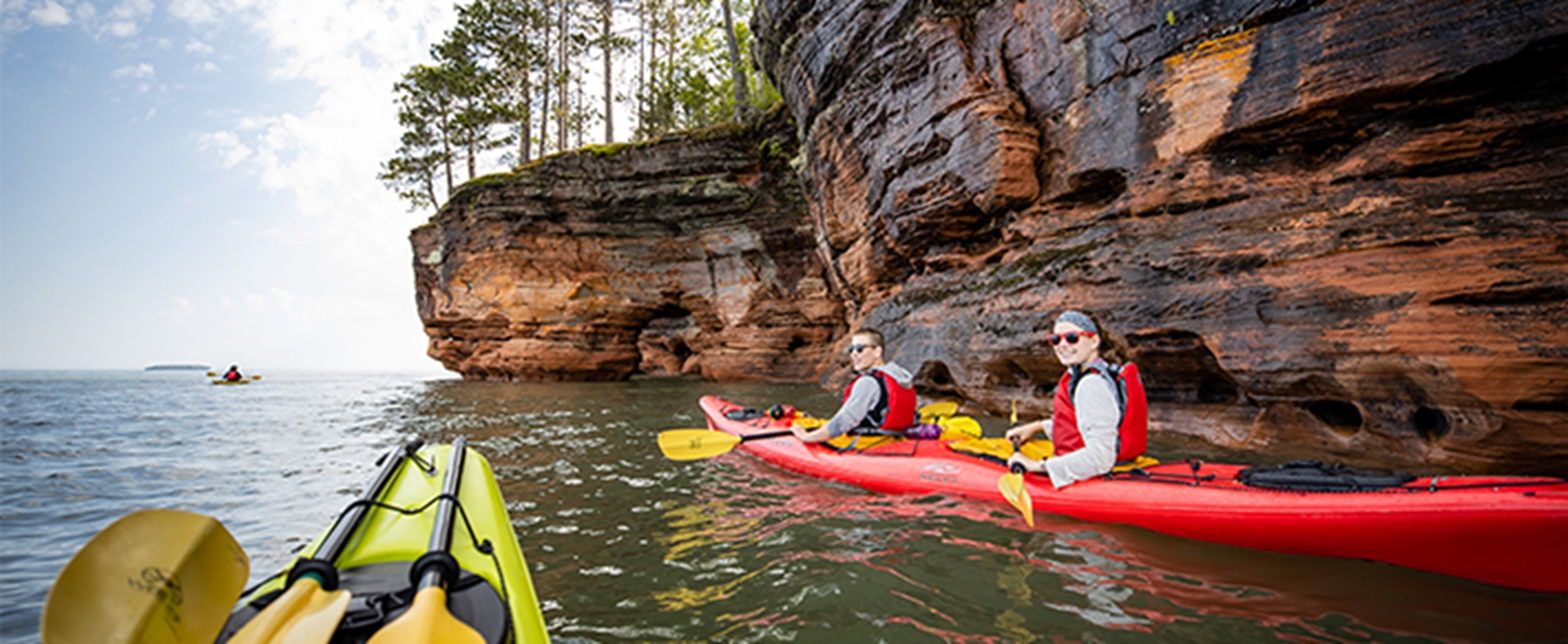 Group kayaking along the sea caves at the Apostle Islands in Bayfield