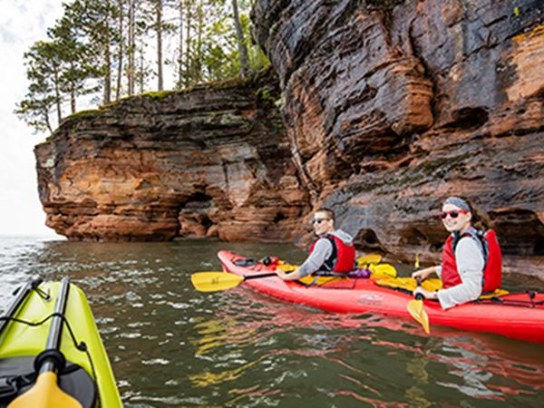 Group kayaking along the sea caves at the Apostle Islands in Bayfield